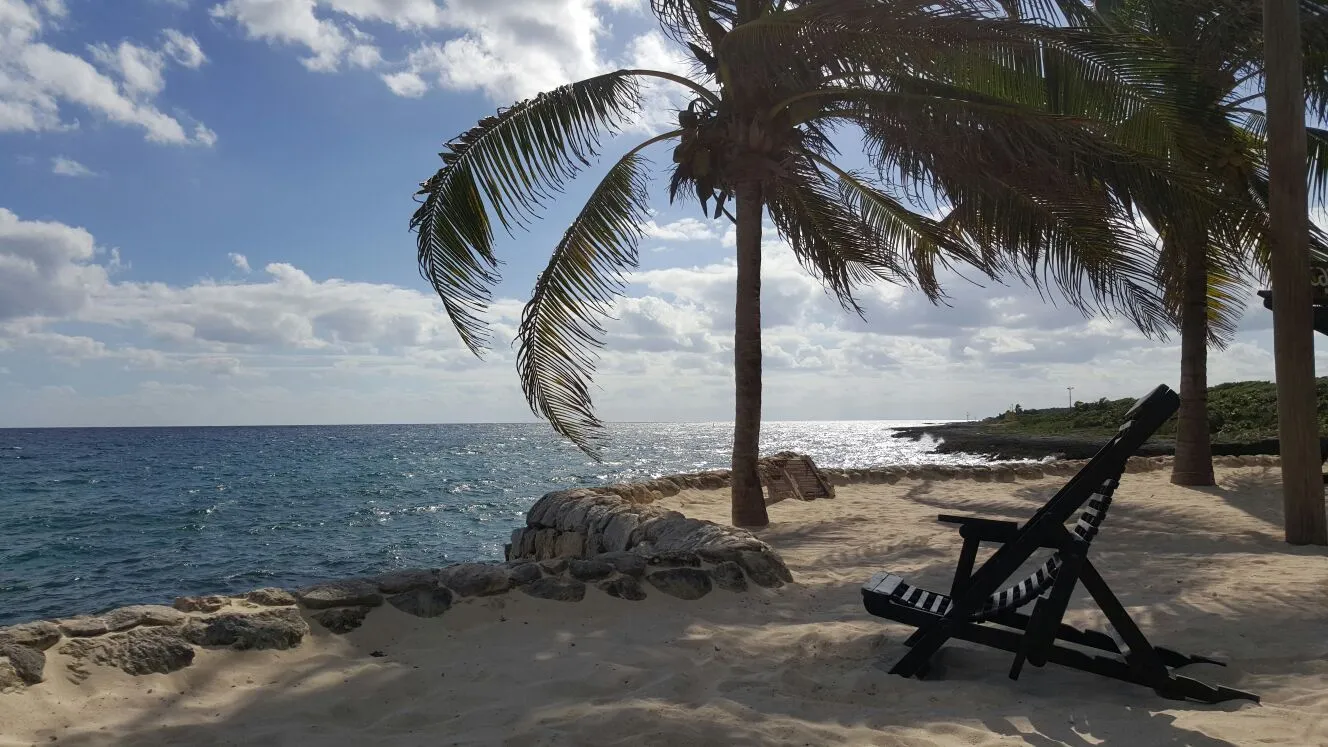 Palm-lined beach cove at Xcaret park on the Riviera Maya, Mexico