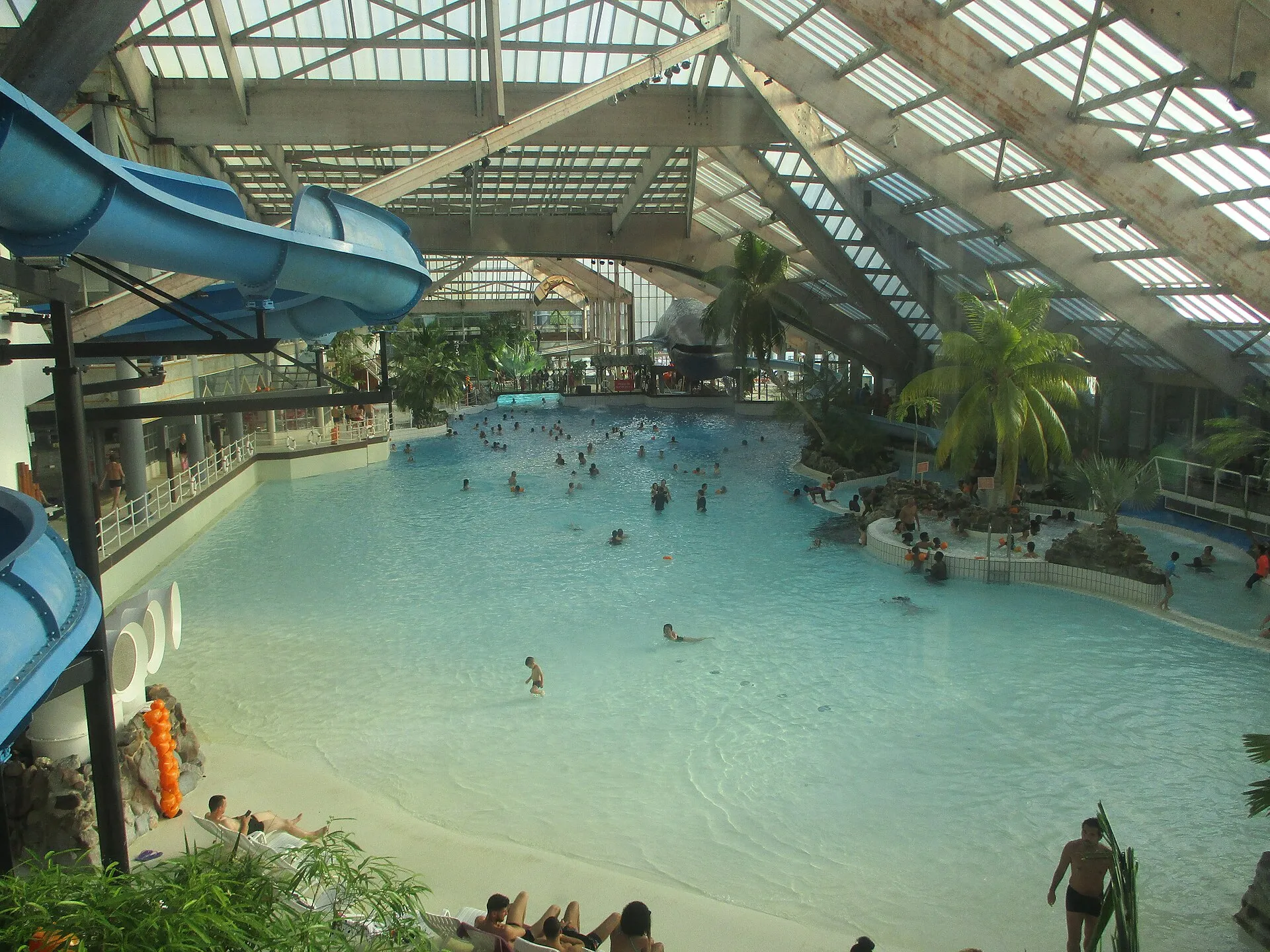 Indoor wave pool and water slides under the glass roof at Aquaboulevard water park in Paris