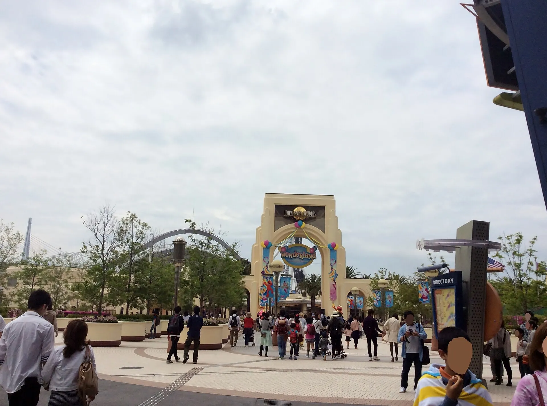 Main entrance arch of Universal Studios Japan in Osaka with visitors walking in