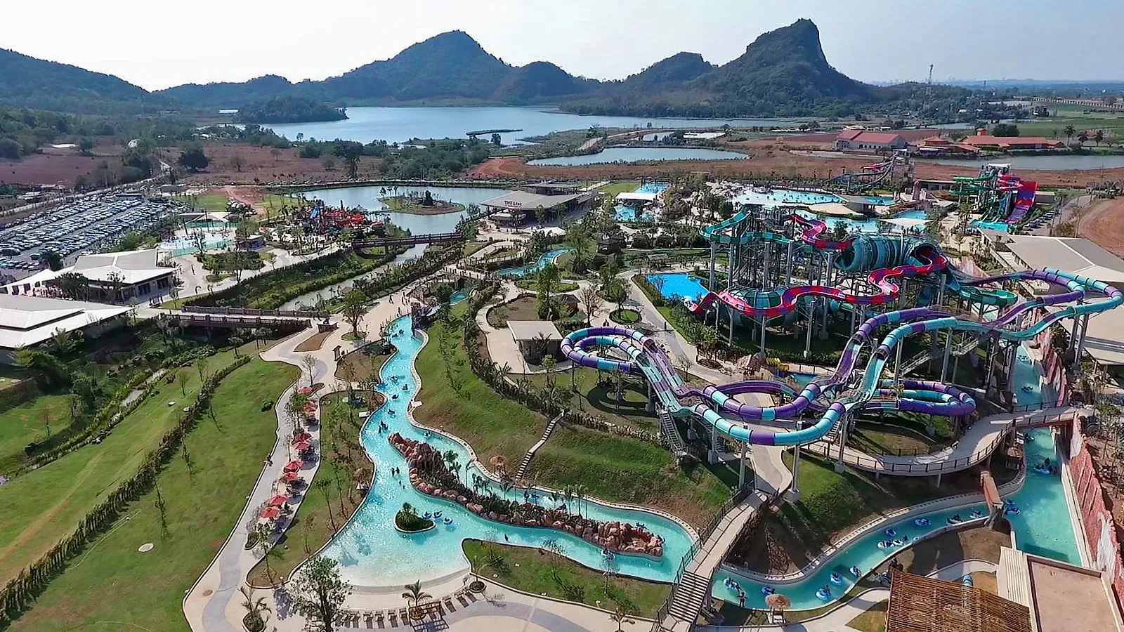 Aerial overview of Ramayana Water Park in Pattaya with its slide towers, lazy river and the Khao Chi Chan hills behind