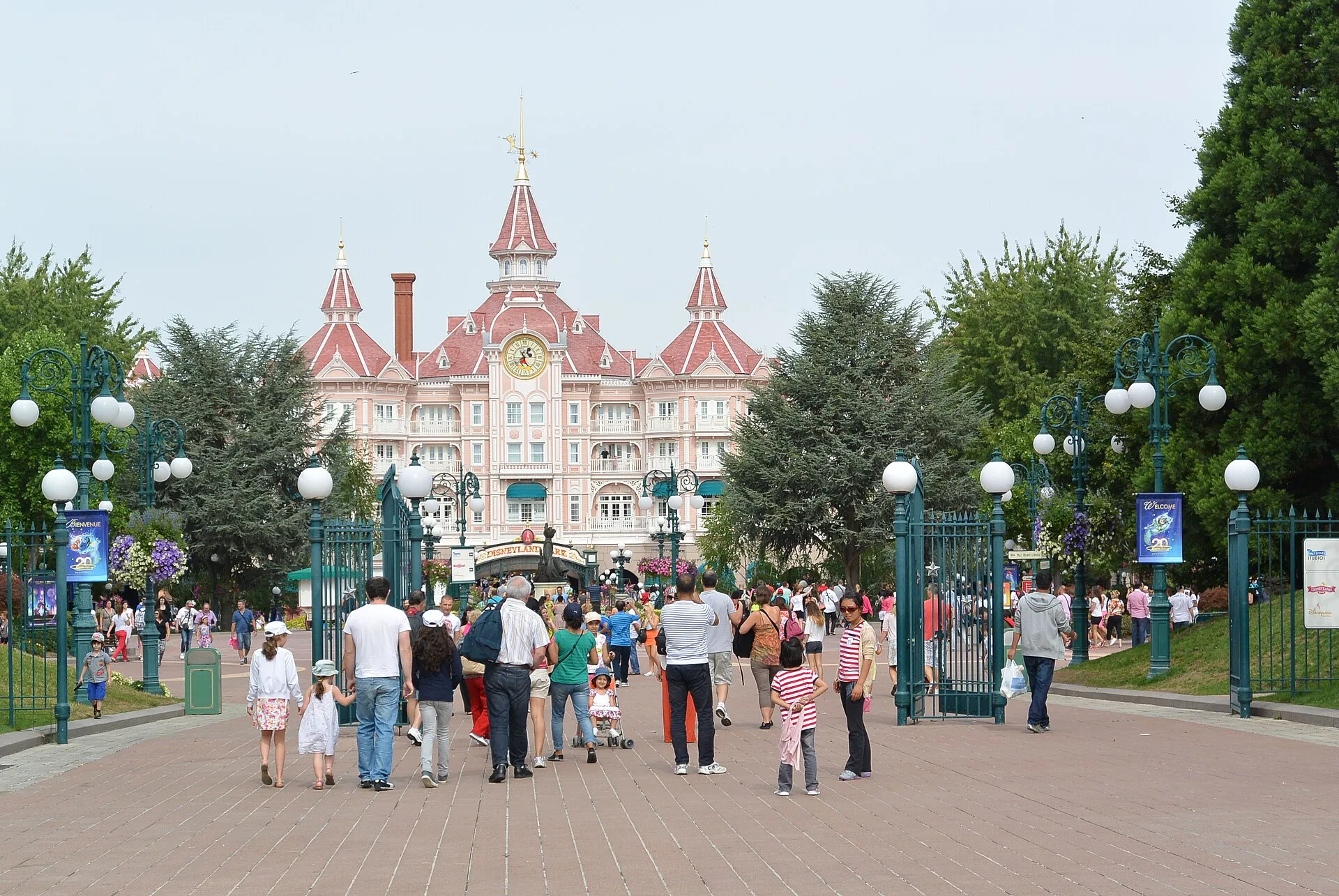 Entrance walkway to Disneyland Park in Paris with the Disneyland Hotel and its clock tower behind the gates