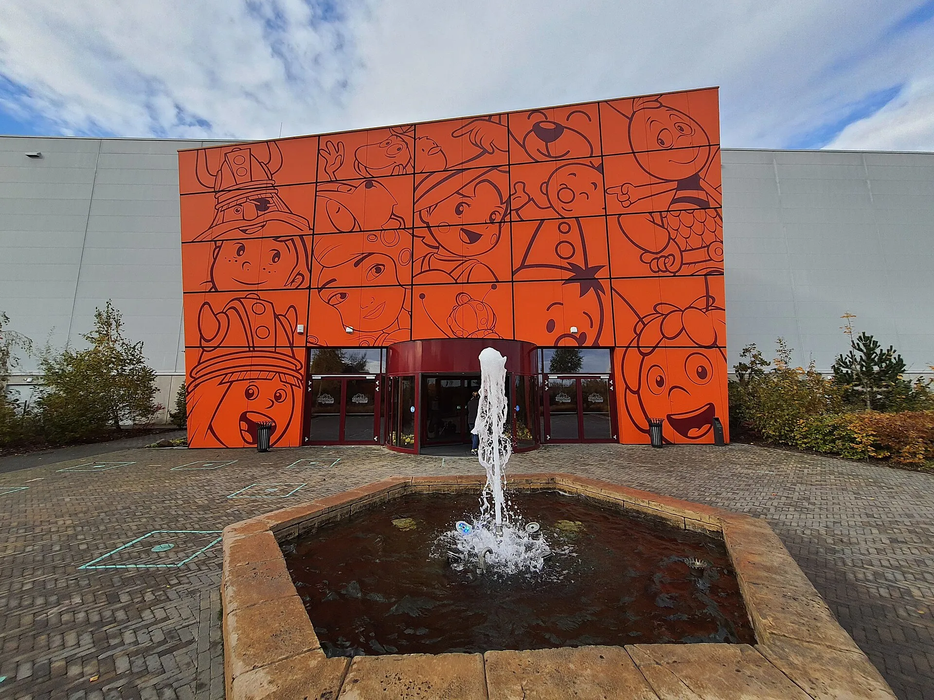 Orange entrance building of Majaland Kownaty covered in Studio 100 cartoon character murals