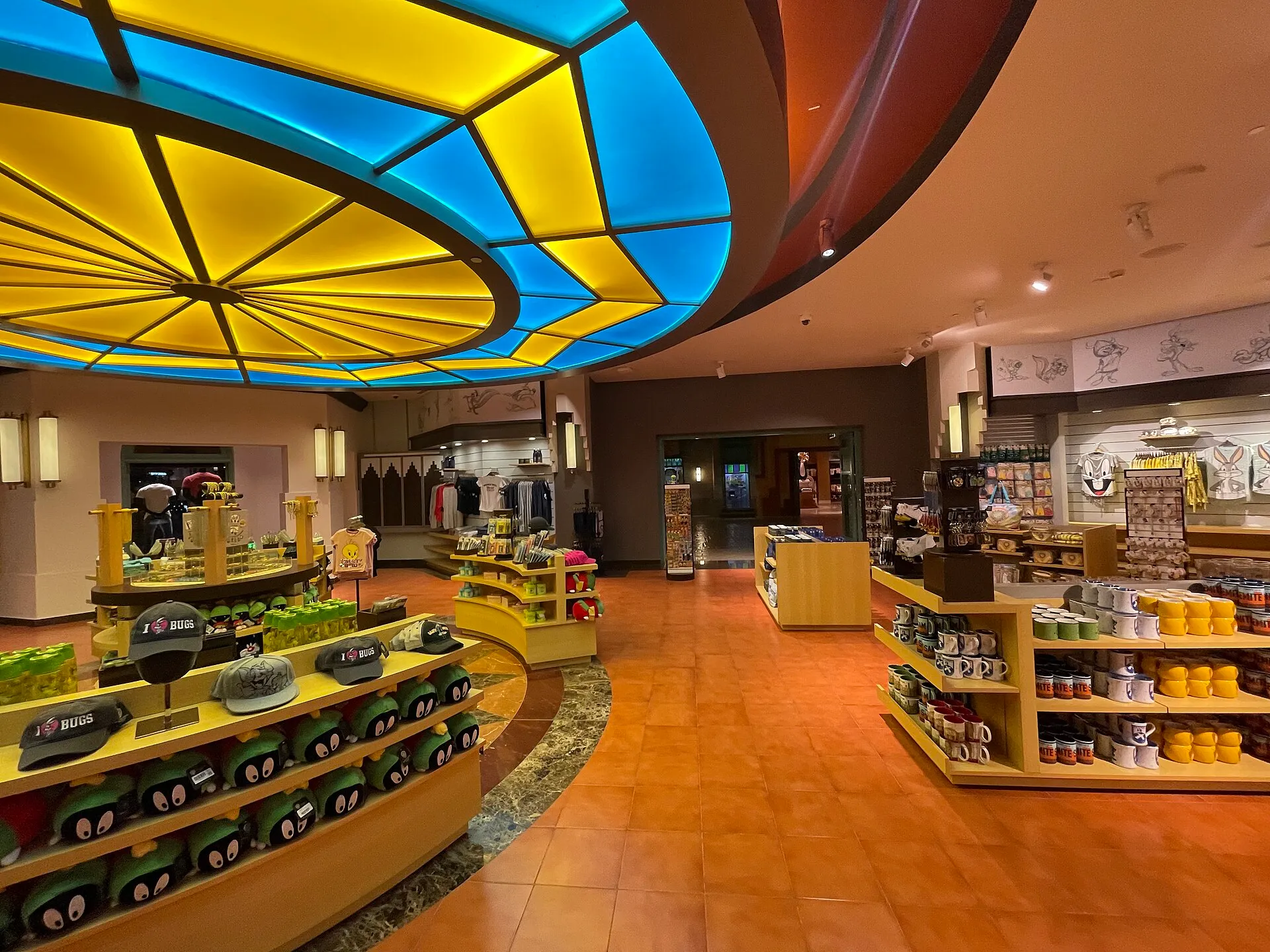 Inside Warner Bros. World Abu Dhabi: the art-deco WB Studio Store under a stained-glass ceiling in Warner Bros. Plaza