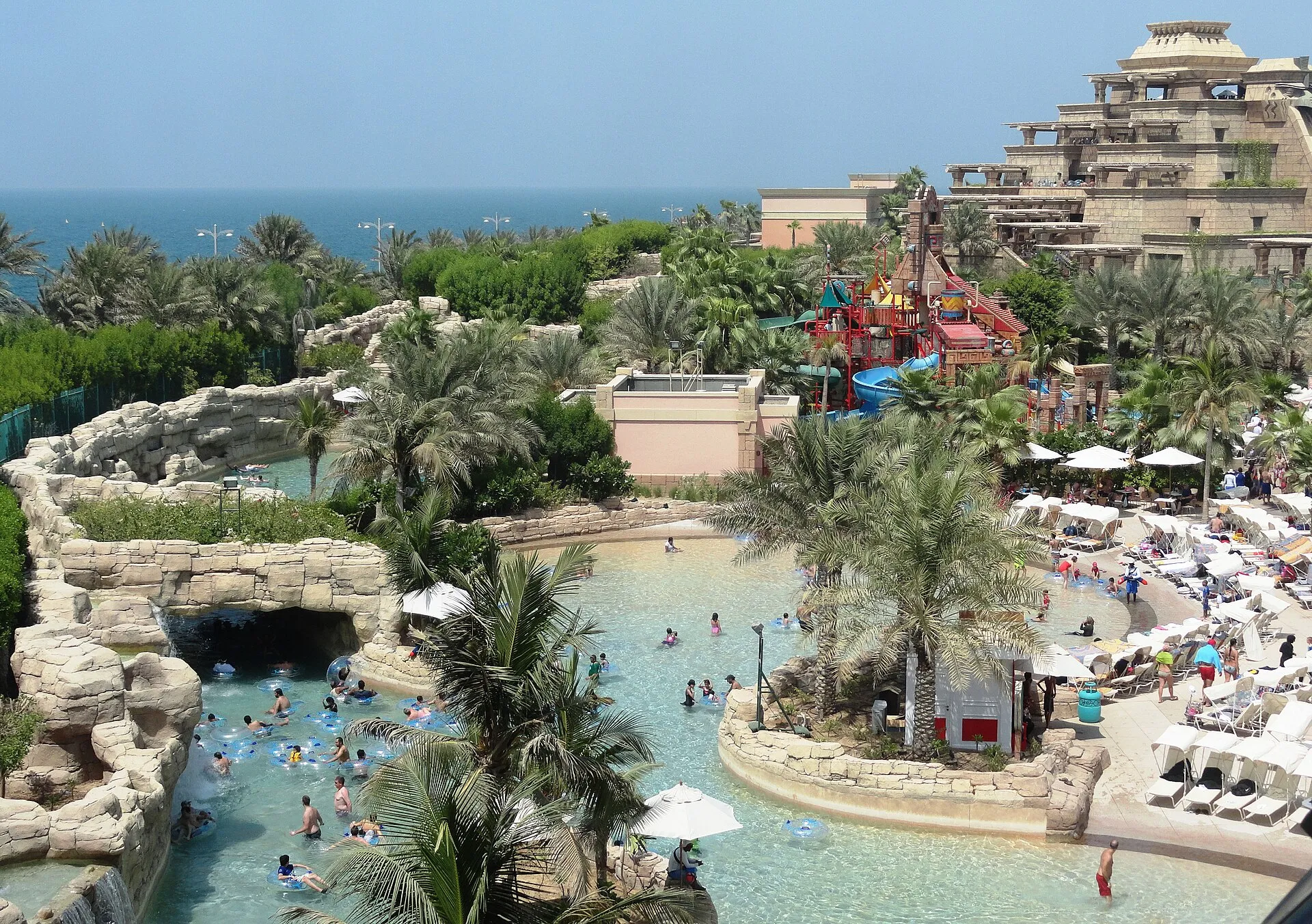 Panorama of Aquaventure waterpark at Atlantis The Palm, Dubai, with the lazy river, pools and slide towers by the sea