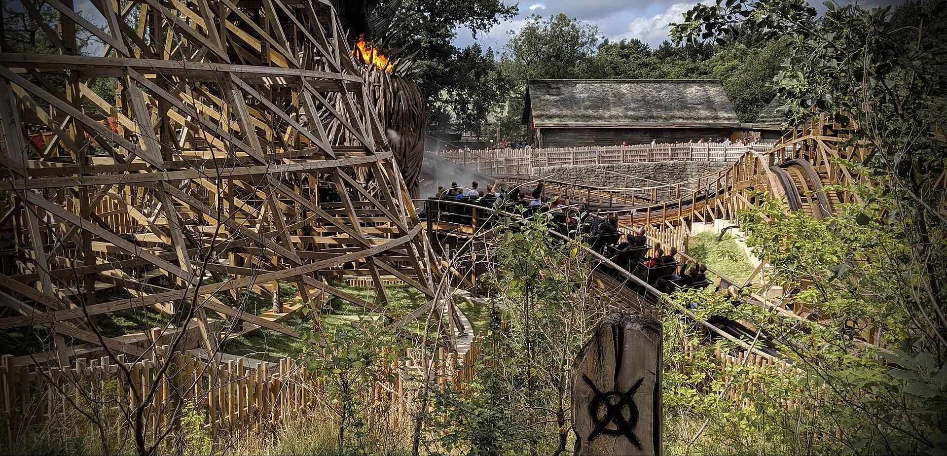 Wicker Man wooden roller coaster train speeding past the burning effigy at Alton Towers